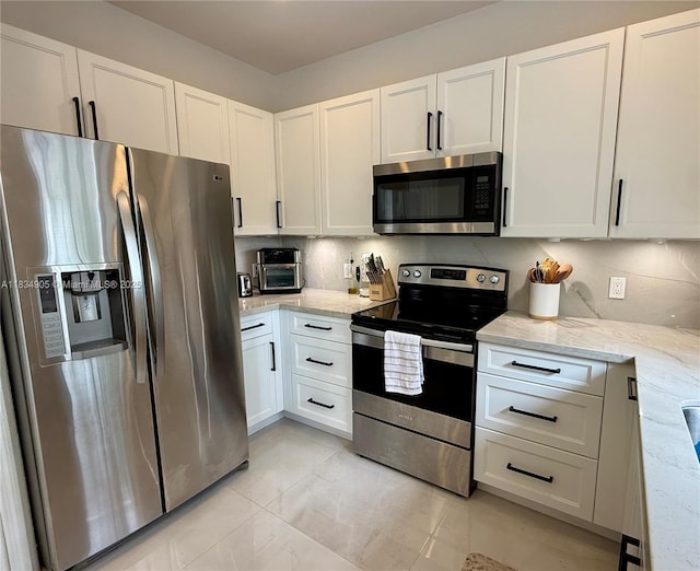 14902 SW 23rd Way, Miami, FL 33185 - kitchen with stainless steel appliances, light stone counters, and white cabinetry