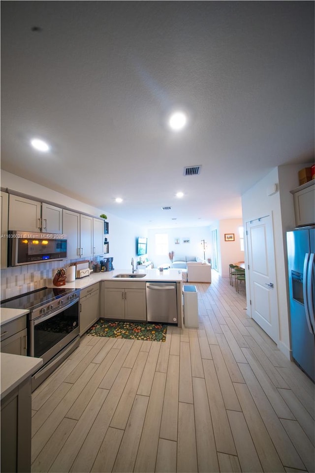 138 SW 171st Way, Pembroke Pines, FL 33027 - kitchen with stainless steel appliances, gray cabinets, light wood-style flooring, open floor plan, and recessed lighting