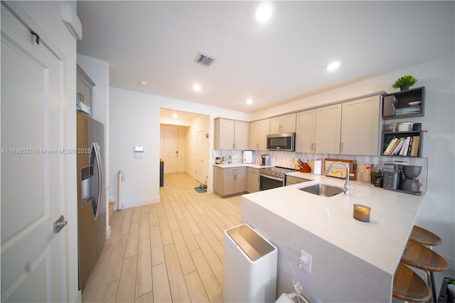 138 SW 171st Way, Pembroke Pines, FL 33027 - kitchen with appliances with stainless steel finishes, a peninsula, tasteful backsplash, light countertops, and a breakfast bar
