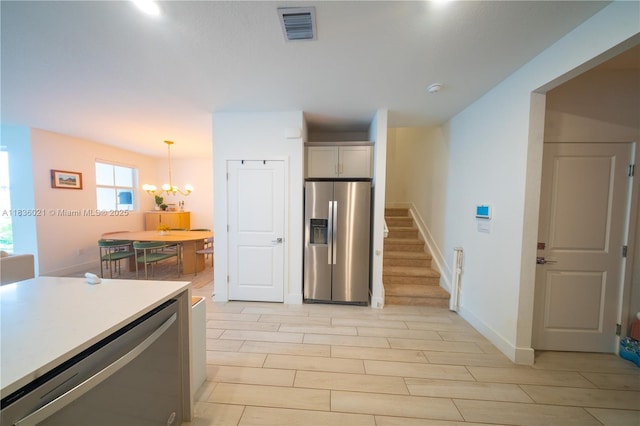 138 SW 171st Way, Pembroke Pines, FL 33027 - kitchen with stainless steel fridge, a chandelier, light wood-style floors, and light countertops