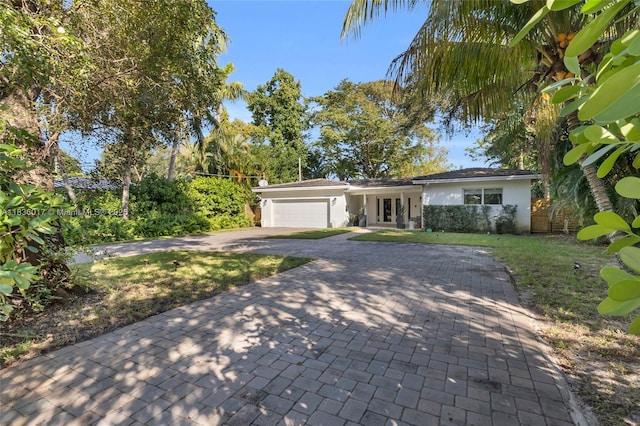 11433 NE 6th Ave, Biscayne Park, FL 33161 - ranch-style house with a garage, decorative driveway, french doors, stucco siding, and a front lawn