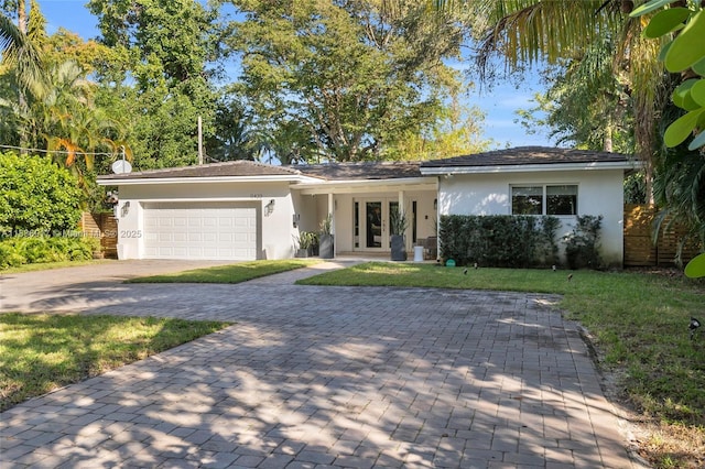 11433 NE 6th Ave, Biscayne Park, FL 33161 - ranch-style house featuring stucco siding, an attached garage, driveway, french doors, and a front yard