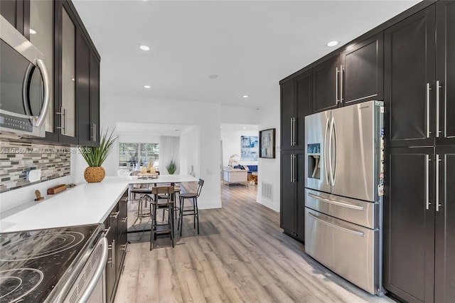 11433 NE 6th Ave, Biscayne Park, FL 33161 - kitchen with appliances with stainless steel finishes, light wood-style flooring, backsplash, light countertops, and recessed lighting