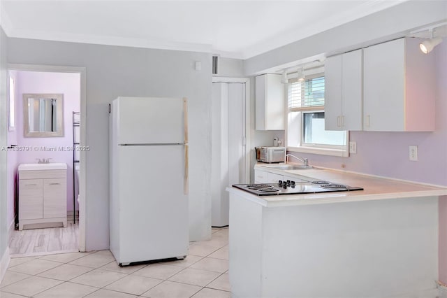 3511 Fairfax Dr, Fort Lauderdale, FL 33312 - kitchen featuring freestanding refrigerator, white cabinets, black electric cooktop, crown molding, and light countertops