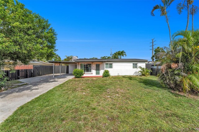 3036 N 58th Ave, Hollywood, FL 33021 - rear view of house with driveway, an attached carport, and stucco siding