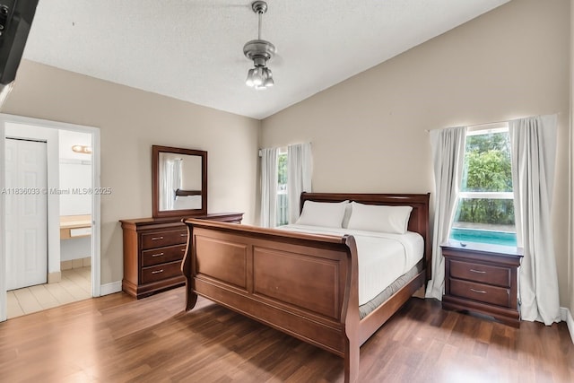 2472 SW 106th Ave, Miramar, FL 33025 - bedroom with vaulted ceiling, multiple windows, dark wood finished floors, and ensuite bathroom