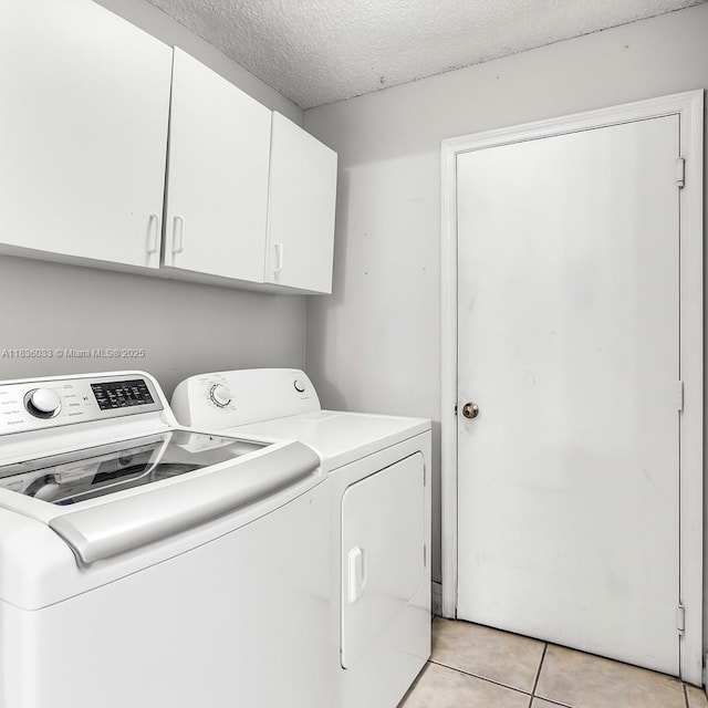 2472 SW 106th Ave, Miramar, FL 33025 - laundry area featuring washer and clothes dryer, cabinet space, light tile patterned flooring, and a textured ceiling