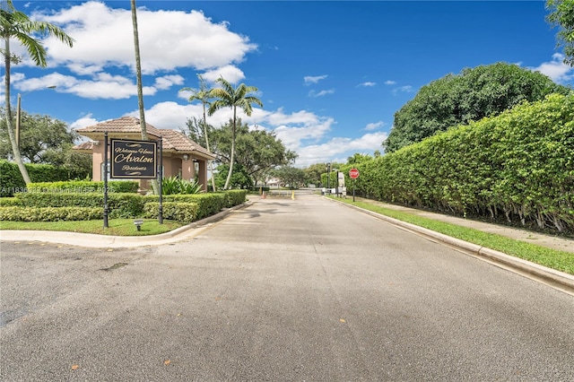 2472 SW 106th Ave, Miramar, FL 33025 - view of asphalt street with traffic signs, street lighting, curbs, and a gated entry