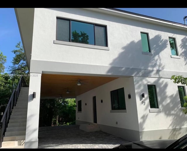 12 Coral Dr, Key Largo, FL 33037 - rear view of property featuring stucco siding, stairway, and a ceiling fan