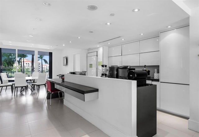 785 Crandon Blvd Unit 302, Key Biscayne, FL 33149 - kitchen with modern cabinets, white cabinetry, dark countertops, recessed lighting, and light tile patterned floors