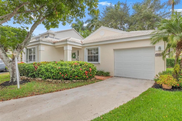 9614 NW 8th Cir, Plantation, FL 33324 - view of front of property with a garage, driveway, and stucco siding