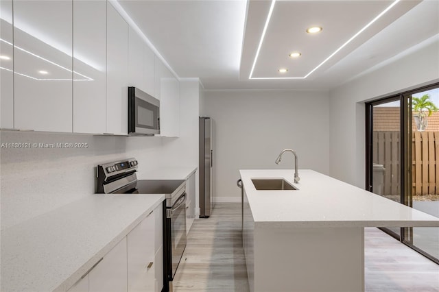 1170 SW 118th Ter, Davie, FL 33325 - kitchen featuring appliances with stainless steel finishes, modern cabinets, light wood-style floors, and recessed lighting