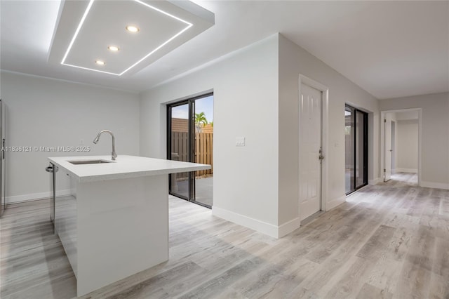 1170 SW 118th Ter, Davie, FL 33325 - kitchen with a kitchen island with sink, light countertops, light wood-style floors, recessed lighting, and a breakfast bar area