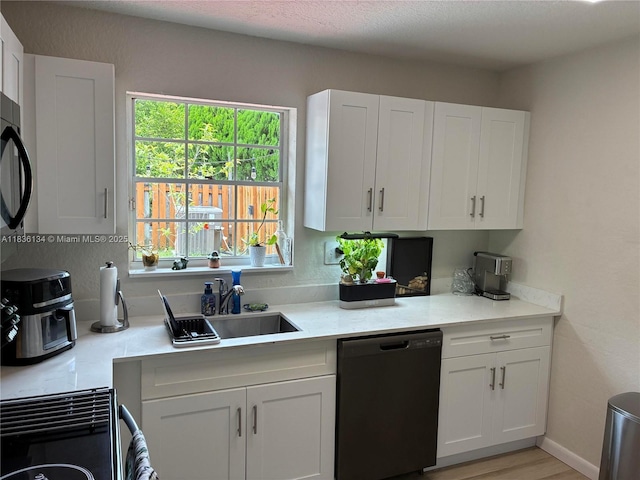 14672 SW 127th Ct, Miami, FL 33186 - kitchen with black dishwasher, light countertops, white cabinets, and healthy amount of natural light