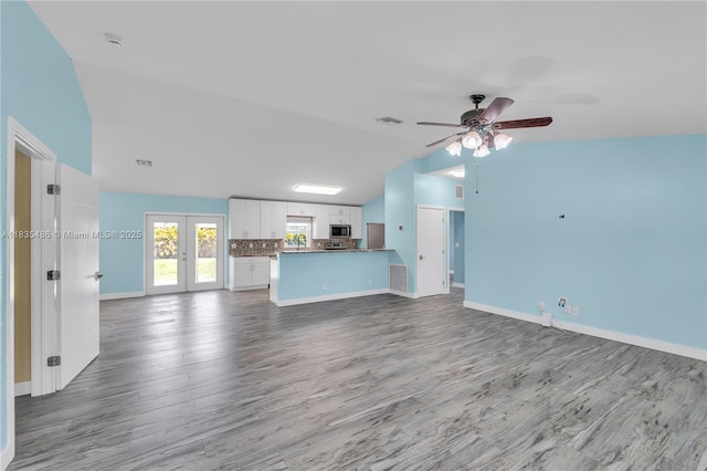 15859 N 68th Ct N, Loxahatchee, FL 33470 - unfurnished living room featuring vaulted ceiling, wood finished floors, ceiling fan, and french doors