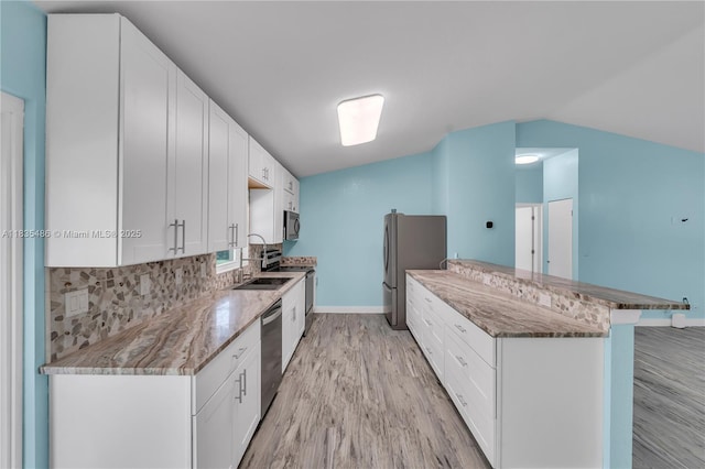 15859 N 68th Ct N, Loxahatchee, FL 33470 - kitchen with stainless steel appliances, light wood-style flooring, lofted ceiling, backsplash, and a peninsula