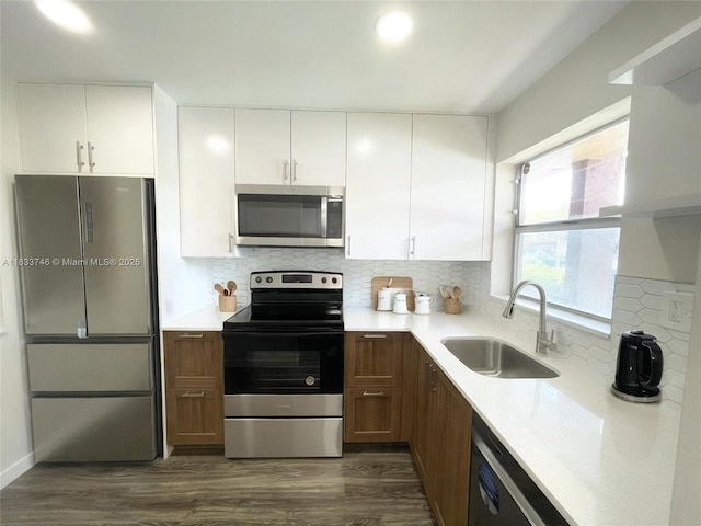 9750 Sunrise Lakes Blvd Unit 109, Sunrise, FL 33322 - kitchen featuring appliances with stainless steel finishes, light countertops, dark wood-type flooring, white cabinets, and decorative backsplash
