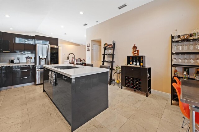 17476 SW 20th St, Miramar, FL 33029 - kitchen featuring modern cabinets, lofted ceiling, light countertops, an island with sink, and stainless steel refrigerator with ice dispenser