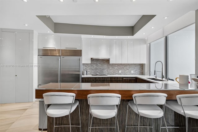 18201 Collins Ave Unit Ts2 & Ts3, Sunny Isles Beach, FL 33160 - kitchen with modern cabinets, white cabinetry, built in fridge, a peninsula, and decorative backsplash