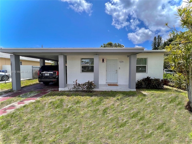 1226 NW 103rd St, Miami, FL 33147 - view of front of property with a front lawn, stucco siding, and a carport