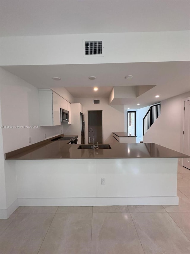 5463 W Oak Way, Dania Beach, FL 33314 - kitchen with appliances with stainless steel finishes, white cabinets, a peninsula, recessed lighting, and dark countertops