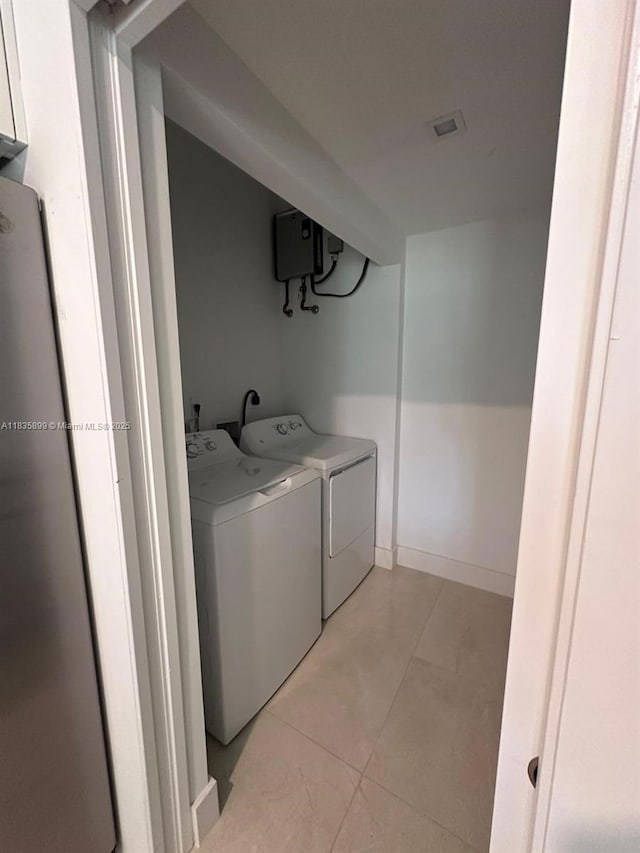 5463 W Oak Way, Dania Beach, FL 33314 - laundry room with washing machine and dryer, water heater, and light tile patterned flooring
