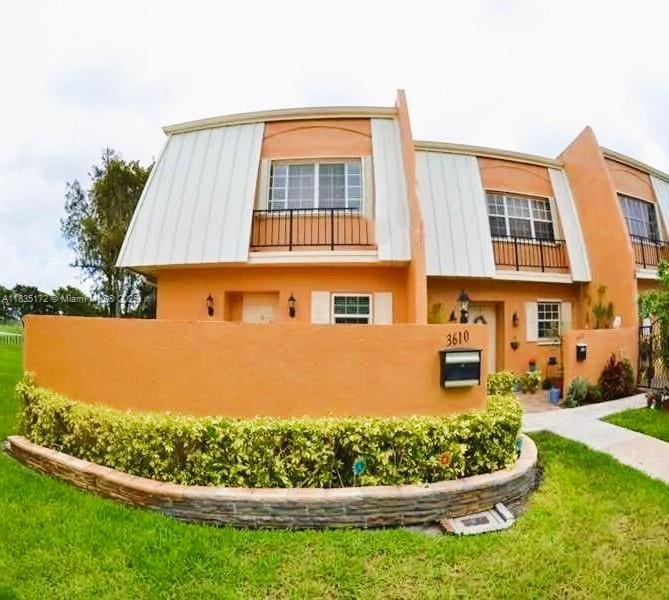 3610 Citrus Trce Unit 1, Davie, FL 33328 - rear view of house featuring stucco siding, a standing seam roof, and a metal roof