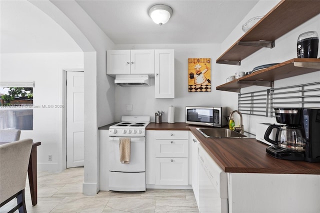 2946 SW 26th St, Miami, FL 33133 - kitchen with white appliances, custom exhaust hood, butcher block countertops, arched walkways, and light marble finish flooring