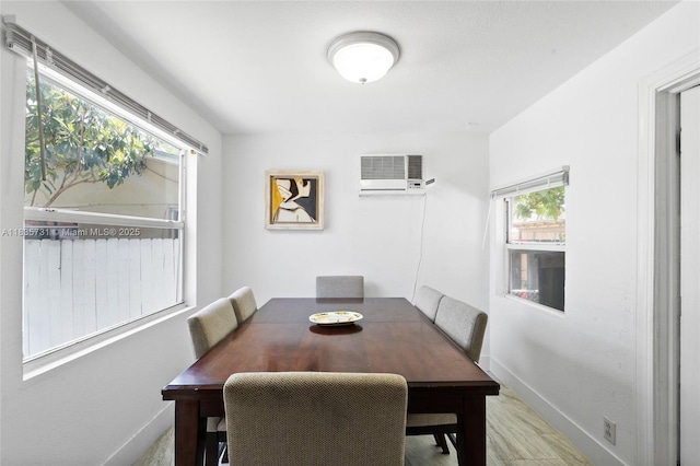 2946 SW 26th St, Miami, FL 33133 - dining room featuring a wall mounted air conditioner, healthy amount of natural light, and wood finished floors