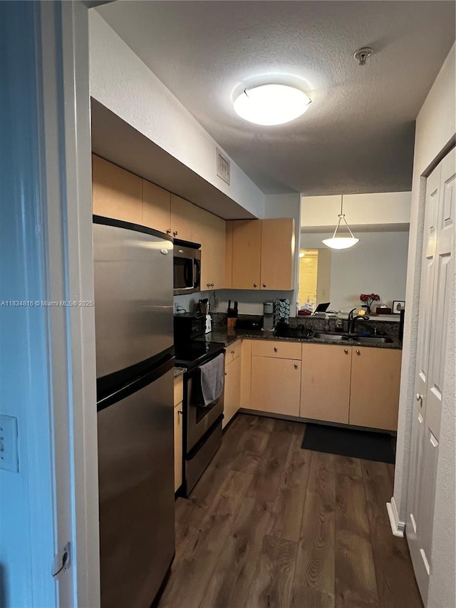 2548 Centergate Dr Unit 301, Miramar, FL 33025 - kitchen with appliances with stainless steel finishes, dark countertops, dark wood-type flooring, a textured ceiling, and hanging light fixtures
