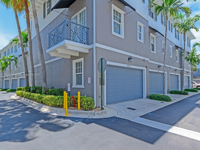 2249 NE 9th Ave, Wilton Manors, FL 33305 - view of property exterior featuring driveway, an attached garage, and stucco siding