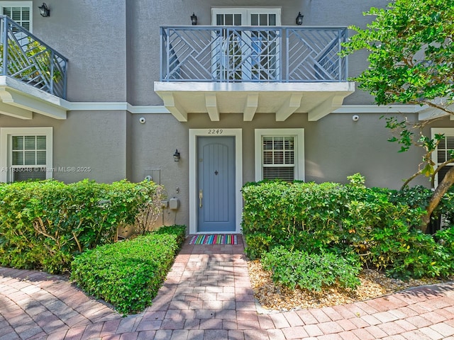 2249 NE 9th Ave, Wilton Manors, FL 33305 - property entrance with a balcony and stucco siding