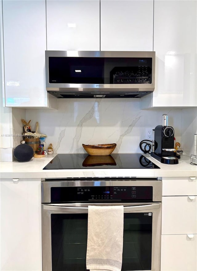 770 Claughton Island Dr Unit 1503, Miami, FL 33131 - kitchen featuring appliances with stainless steel finishes, white cabinetry, light countertops, and decorative backsplash