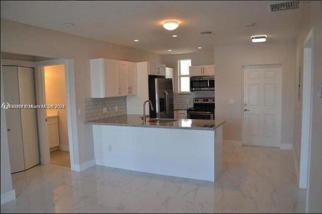 555 E Dania Beach Blvd Unit 5, Dania Beach, FL 33004 - kitchen featuring appliances with stainless steel finishes, tasteful backsplash, stone counters, a peninsula, and white cabinets
