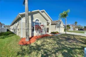 1851 Soaring Hights Cir, Orlando, FL 32837 - view of side of home with a yard, a garage, and concrete driveway
