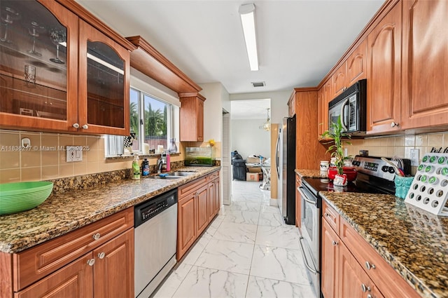 11652 SW 142nd Ct, Miami, FL 33186 - kitchen featuring appliances with stainless steel finishes, light marble finish flooring, dark stone counters, and backsplash
