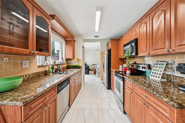 11652 SW 142nd Ct, Miami, FL 33186 - kitchen featuring stainless steel appliances, light marble finish floors, dark stone countertops, glass insert cabinets, and tasteful backsplash