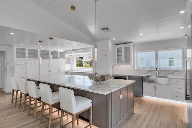 126 Villa Bella Dr, Islamorada, FL 33036 - kitchen featuring stainless steel dishwasher, light wood-style flooring, white cabinets, glass insert cabinets, and recessed lighting