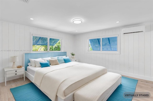 126 Villa Bella Dr, Islamorada, FL 33036 - bedroom with a wall mounted AC, light wood-style floors, and recessed lighting