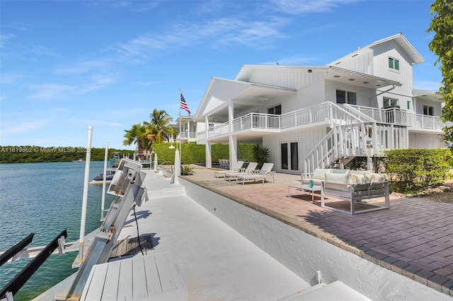 126 Villa Bella Dr, Islamorada, FL 33036 - dock with stairs, a patio area, boat lift, a water view, and an outdoor hangout area