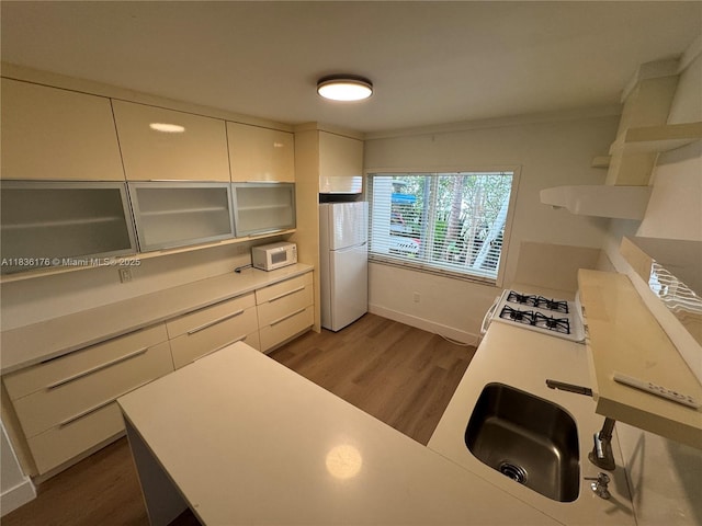 4780 Pine Tree Dr Unit U-2, Miami Beach, FL 33140 - kitchen with white appliances, wood finished floors, white cabinetry, and light countertops