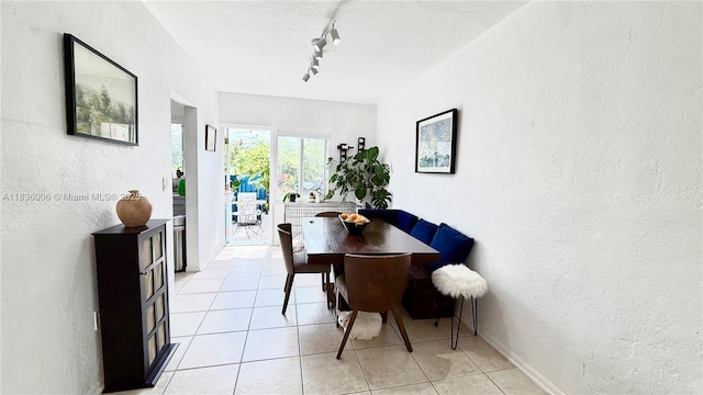 8449 NW 4th Ave Unit 8449, Miami, FL 33150 - dining area featuring a textured wall, rail lighting, light tile patterned floors, and a textured ceiling