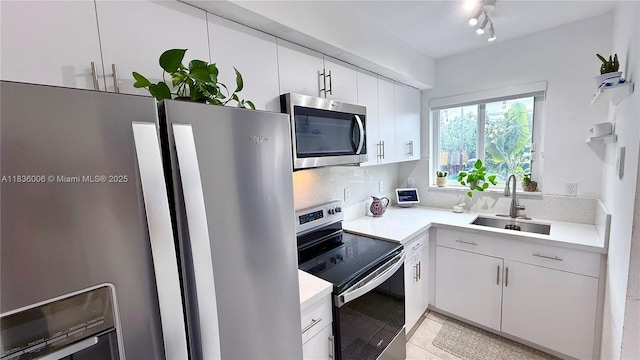 8449 NW 4th Ave Unit 8449, Miami, FL 33150 - kitchen featuring appliances with stainless steel finishes, light countertops, white cabinets, light tile patterned floors, and backsplash