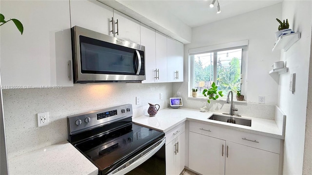 8449 NW 4th Ave Unit 8449, Miami, FL 33150 - kitchen featuring appliances with stainless steel finishes, light countertops, white cabinets, and decorative backsplash