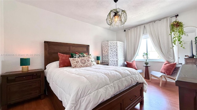 8449 NW 4th Ave Unit 8449, Miami, FL 33150 - bedroom with wood finished floors, a chandelier, and a textured ceiling