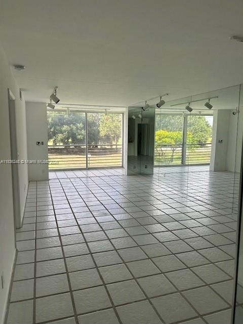 3503 Oaks Way Unit 212, Pompano Beach, FL 33069 - empty room featuring tile patterned floors and rail lighting