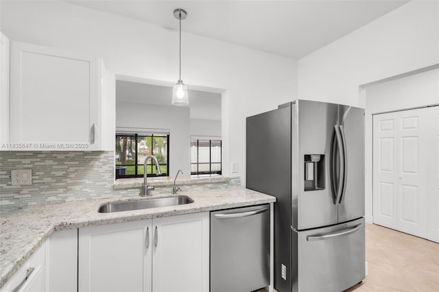 21160 Mainsail Cir Unit H12, Aventura, FL 33180 - kitchen featuring appliances with stainless steel finishes, white cabinets, light tile patterned flooring, light stone counters, and tasteful backsplash