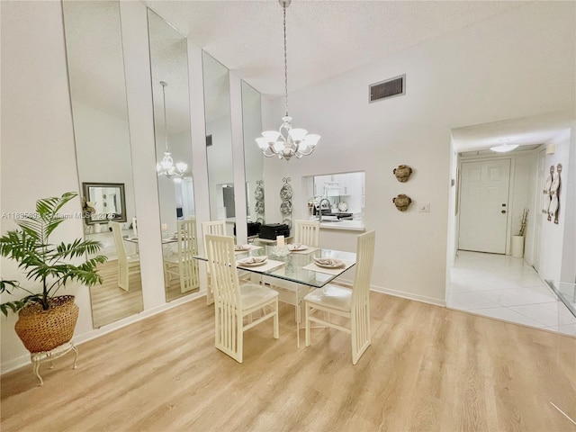 3137 S Carambola Cir S Unit 2369, Coconut Creek, FL 33066 - dining area with high vaulted ceiling, a chandelier, and light wood-style flooring