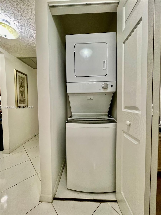 3137 S Carambola Cir S Unit 2369, Coconut Creek, FL 33066 - washroom with stacked washer / dryer, light tile patterned floors, and a textured ceiling