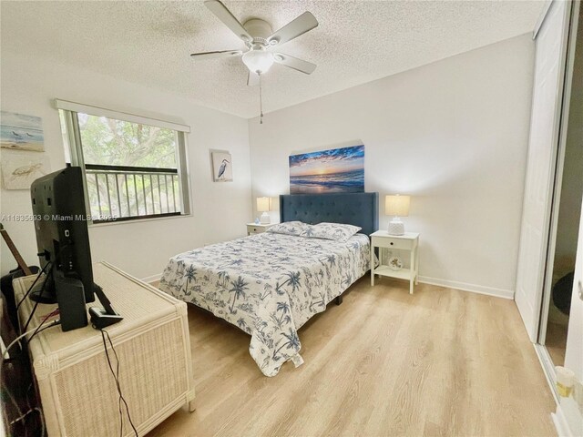 3137 S Carambola Cir S Unit 2369, Coconut Creek, FL 33066 - bedroom featuring light wood-style flooring, a textured ceiling, and a ceiling fan